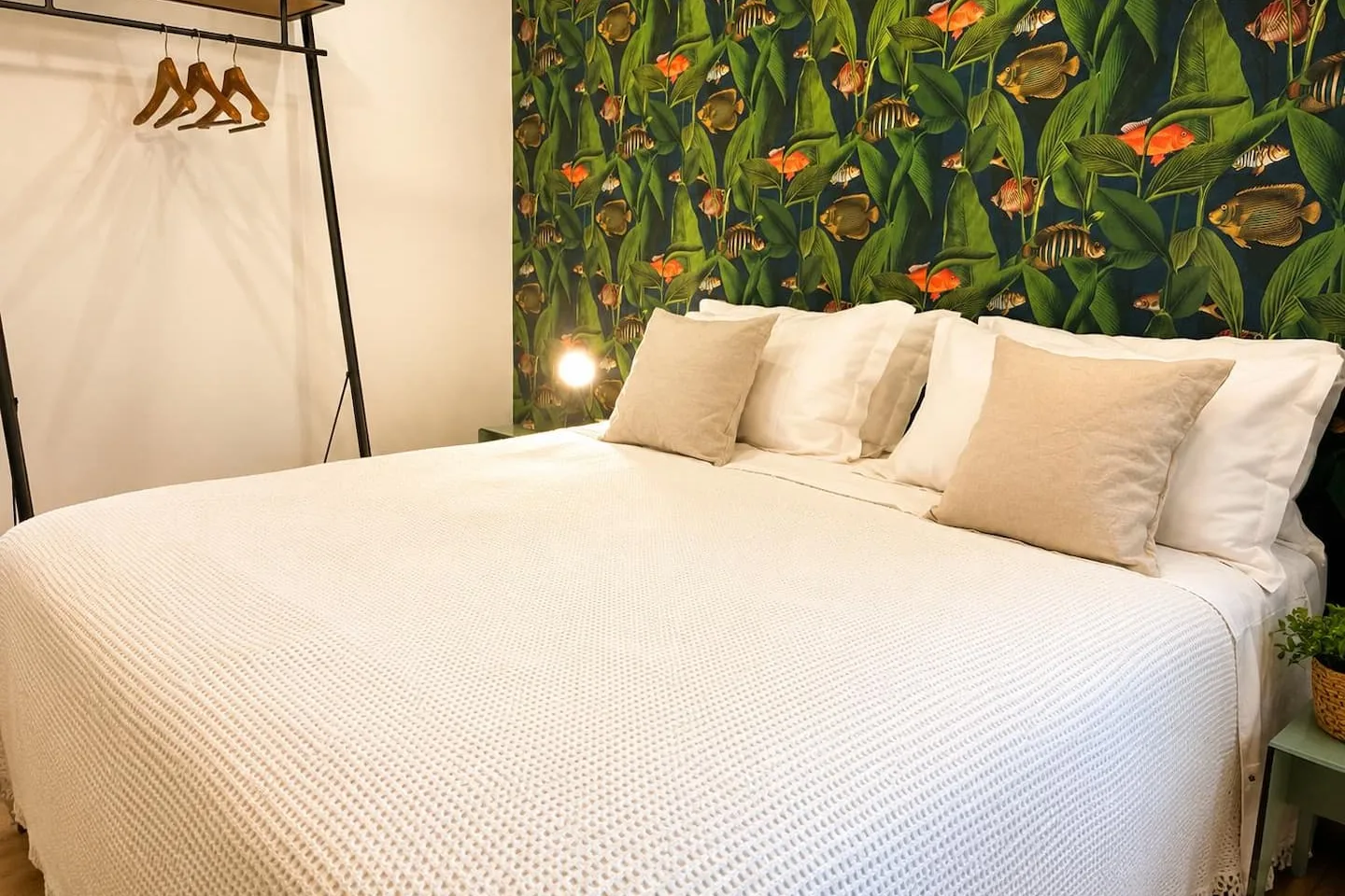 Il letto king size davanti alla parete botanica