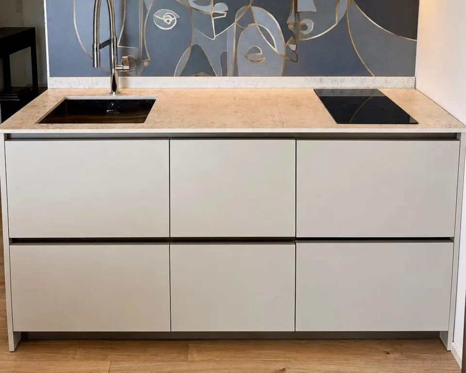 La cucina bianca a vista, con il piano cottura e il paraschizzi decorato