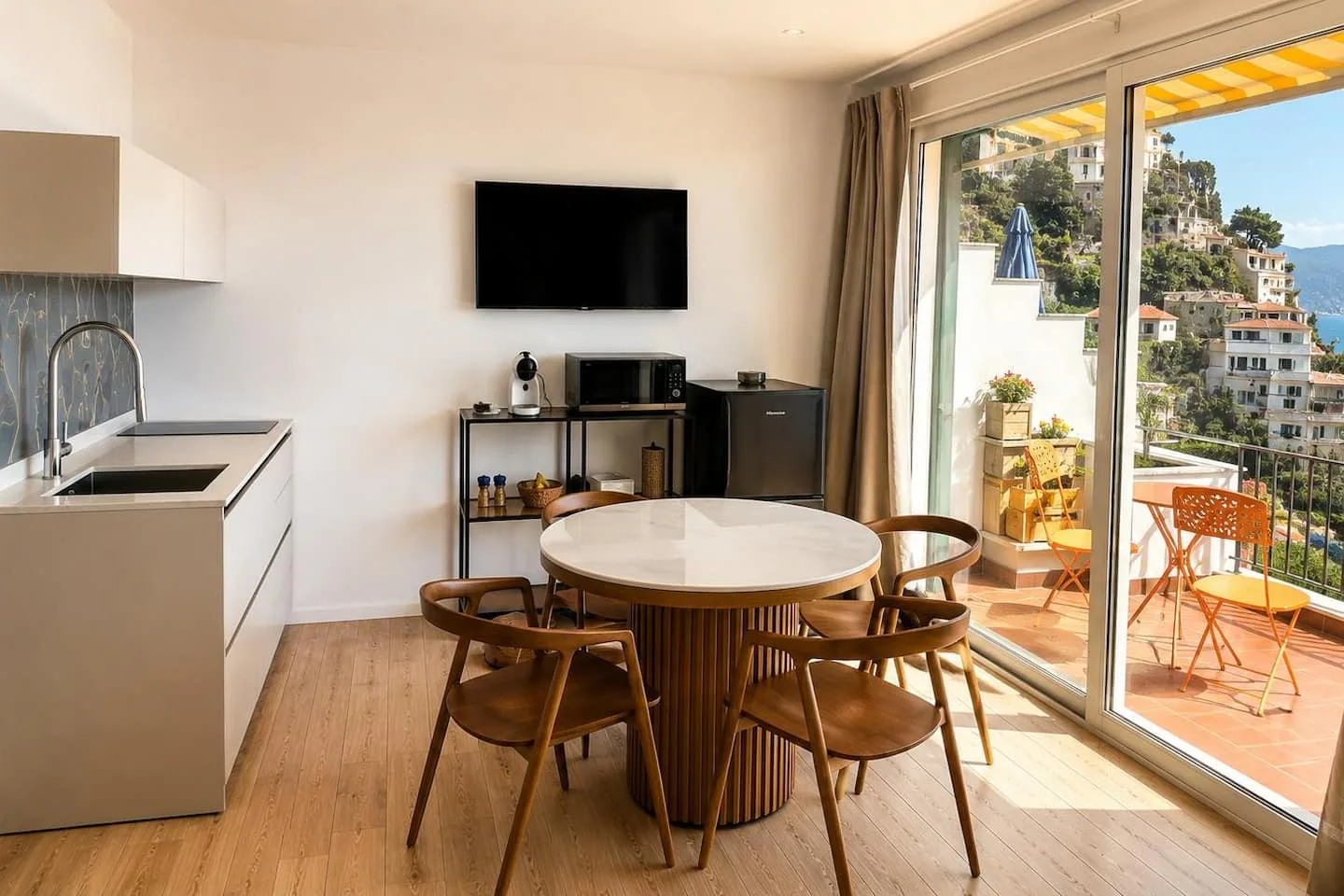 La cucina a vista e il tavolo da pranzo, con la porta finestra sul terrazzo